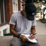 A man writing his hs story on a notebook